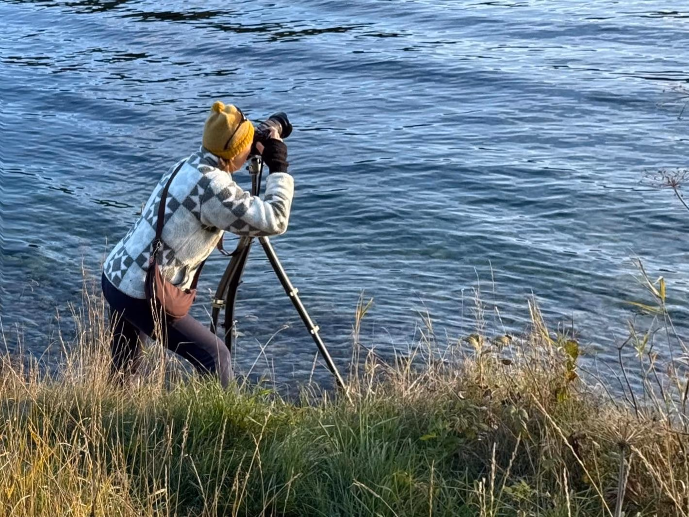 Janet fotografiert am Seeufer durch den Sucher